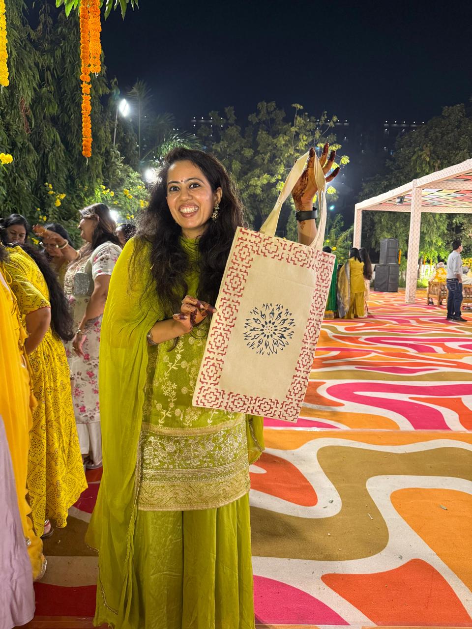 Guest at a function holding a block-printed cream cotton tote bag