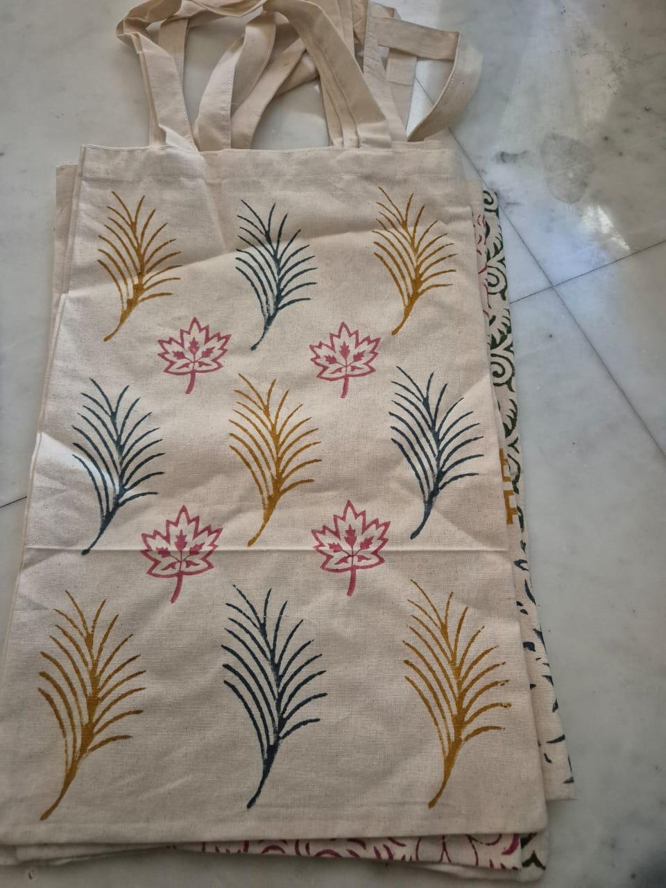 Cream cotton tote bags hand block-printed with teal and mustard leaf motifs