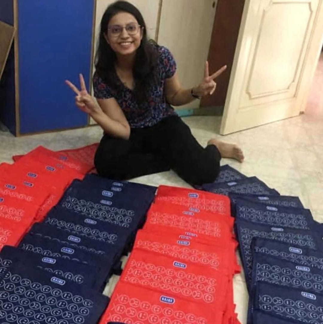 Customer seated beside rows of red and blue printed bags ready for delivery